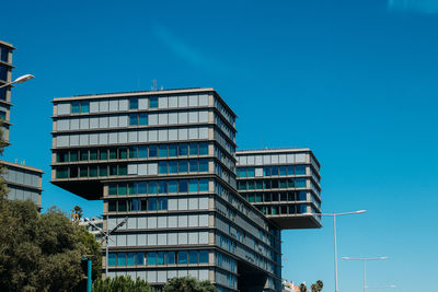 Low angle view of modern building against clear blue sky