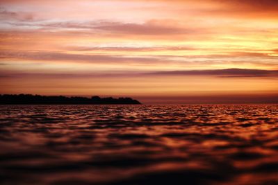 Water surface view of sea against sky during sunset