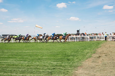 People running on field against sky