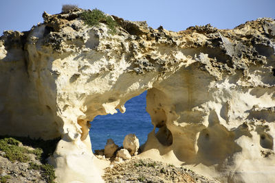 Rock formations by sea against sky