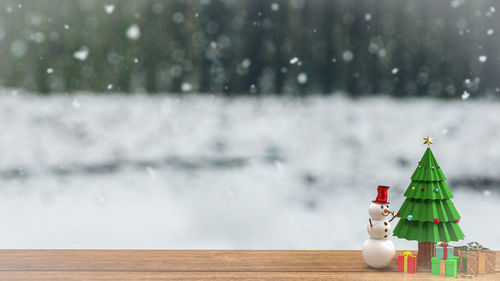 Toy on snow against trees during winter