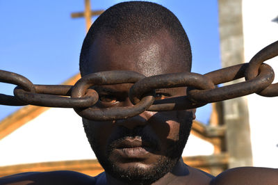 Close-up portrait of young man against sky