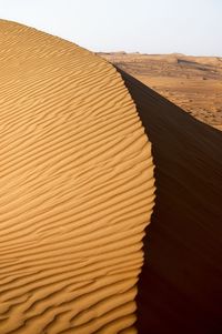 Sand dune in desert against clear sky