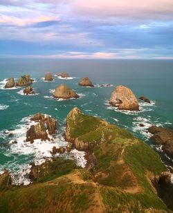 Scenic view of rocks in sea against sky