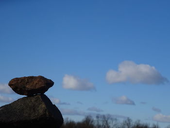 Low angle view of rocks against blue sky
