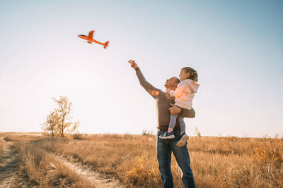 Happy father and child smiling dad and daughter spending time together, let an airplane into the sky