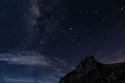 Low angle view of mountain against star field