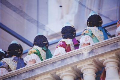 Low angle view of women standing by railing