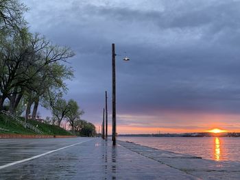 Street by road against sky during sunset