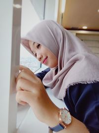 Side view of thoughtful young woman looking through boat window