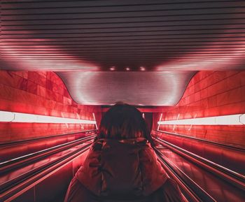 Rear view of woman on escalator