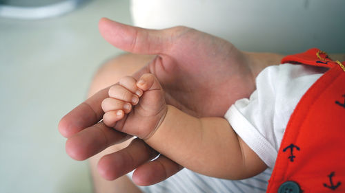Cropped image of parent touching baby hand