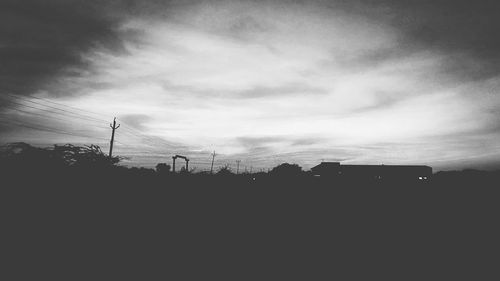 Silhouette of men against cloudy sky