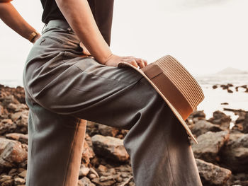 Low section of man holding woman sitting on beach