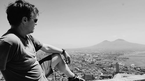 Man looking at cityscape against sky