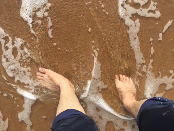 Low section of people standing on beach