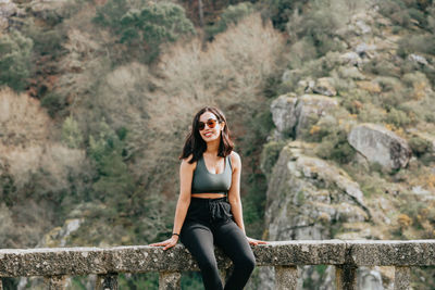 Young woman standing against mountain