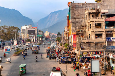 High angle view of vehicles on road along buildings