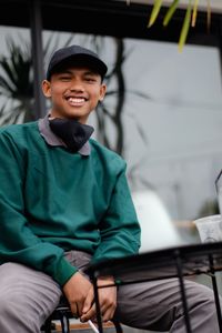 Portrait of smiling boy sitting outdoors