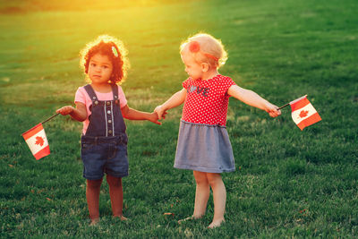 Full length of a smiling girl standing on grass