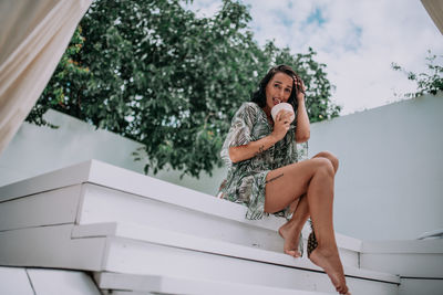 Low angle view of woman sitting outdoors