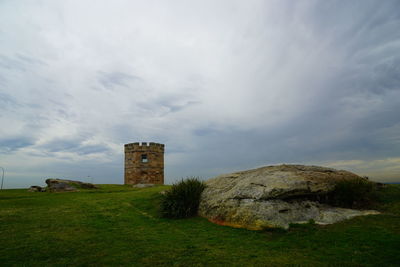 Old building on field against sky