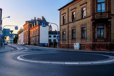 City street by buildings against sky