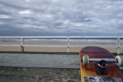 Metal railing by sea against sky