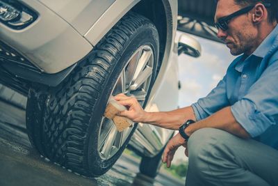 Man cleaning car tire