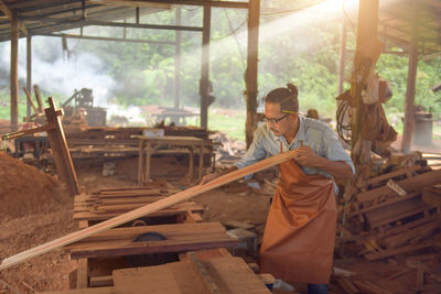 Carpenters using circular saw in workshop