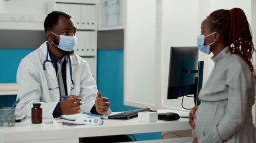 Doctor talking with pregnant woman at clinic