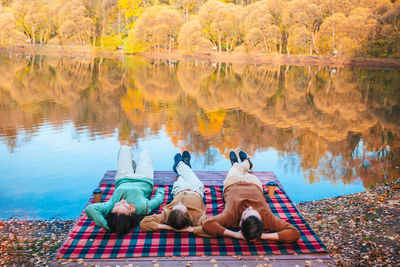 People relaxing in lake during autumn