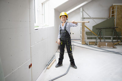 Low angle view of young man standing against wall