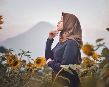 Side view of person standing on flowering plant