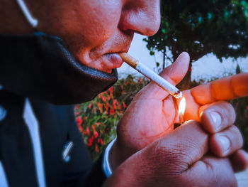 Close-up of man holding cigarette