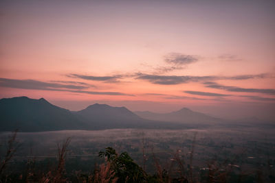 Scenic view of silhouette mountains against romantic sky at sunset