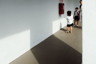 Children by pay phone in corridor at school