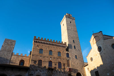 Ncient buildings in the main square of city of san gimignano in early morning, tuscany