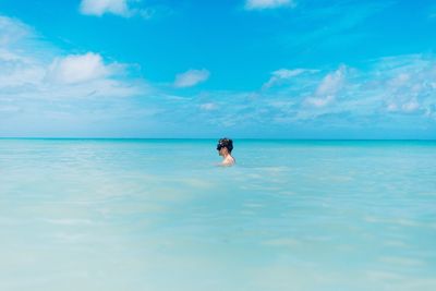 Man in sea against sky