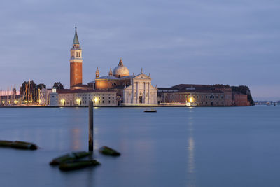 Buildings at waterfront against sky