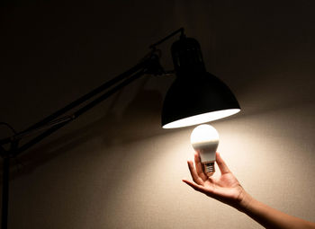 Close-up of hand holding light bulb