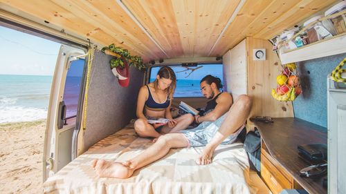 People sitting on beach by sea