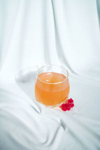 Close-up of orange drink against white background 