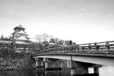 Low angle view of bridge over river against buildings