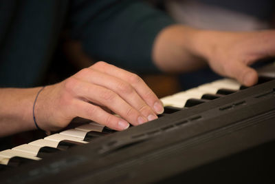 Close-up of hands playing piano