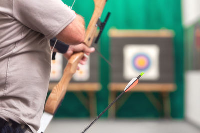 Midsection of man playing archery