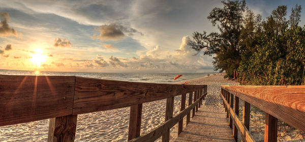 Boardwalk leading toward delnor-wiggins state park at sunset in naples, florida.