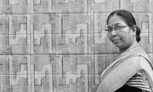 Portrait of woman in sari standing by wall