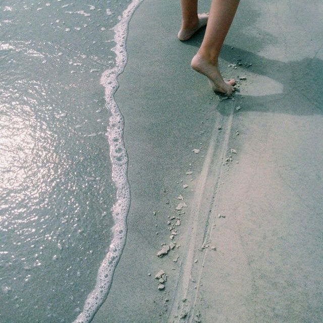 water, low section, person, lifestyles, sea, leisure activity, wet, waterfront, high angle view, vacations, human foot, beach, day, men, motion, unrecognizable person, part of