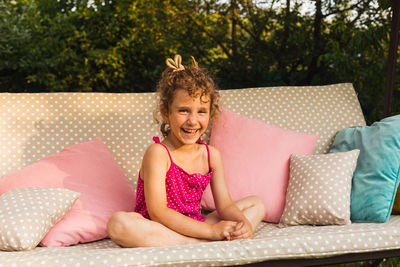 Portrait of smiling girl sitting outdoors